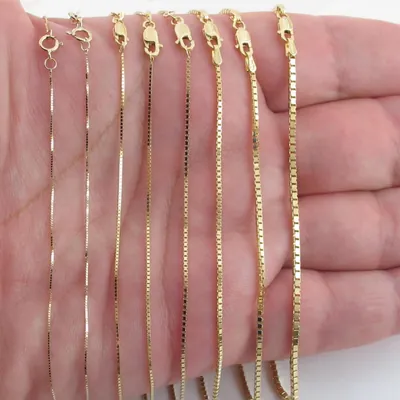 Eight 14k gold box chains of increasing width across a palm