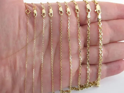 The cable chain listing photo: nine gold cable chains across a palm, finest on the left, thickest on the right