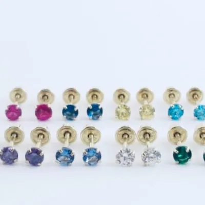 Rows of 14k gold children’s birthstone stud earrings with screw backs