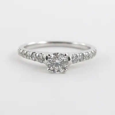 A 14k white gold diamond solitaire engagement ring with diamond accents