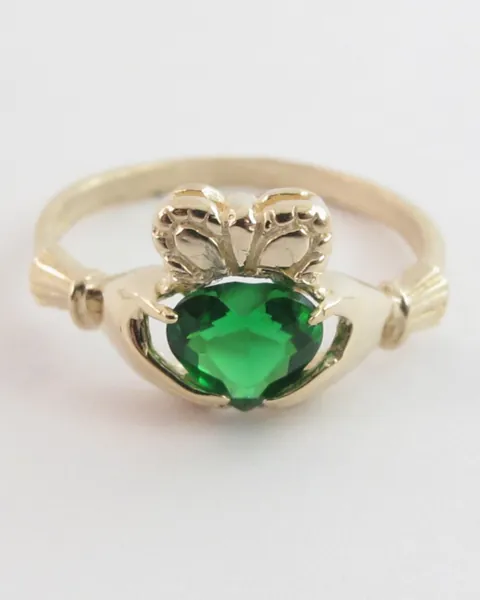 A 14k yellow gold Irish Claddagh ring with a green heart-shaped stone
