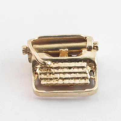 A vintage 14k gold typewriter charm with movable parts